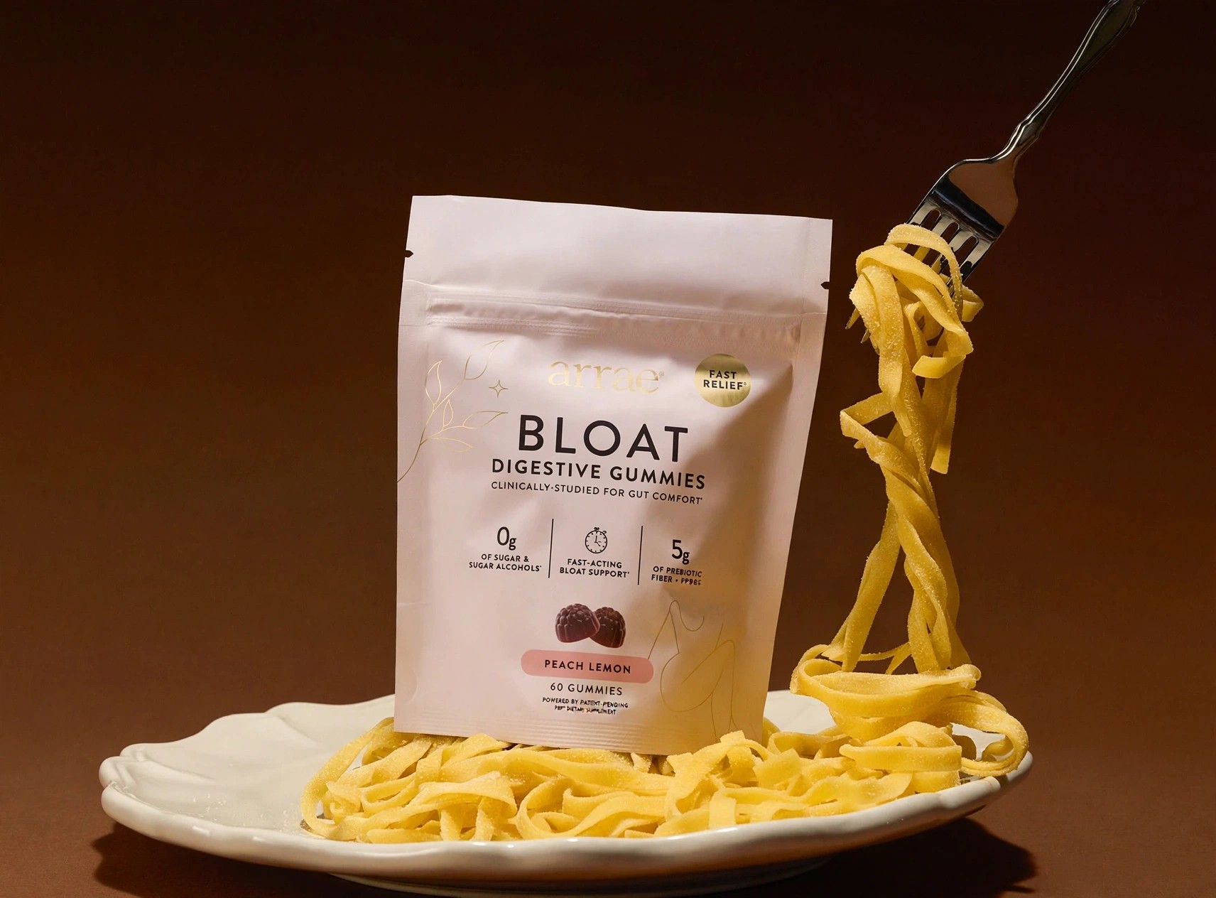 A pouch of Bloat gummies presented with a pasta dish.