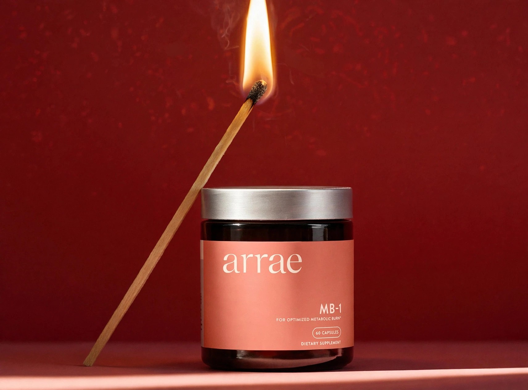 MB-1 supplement jar posed against a red background with match.
