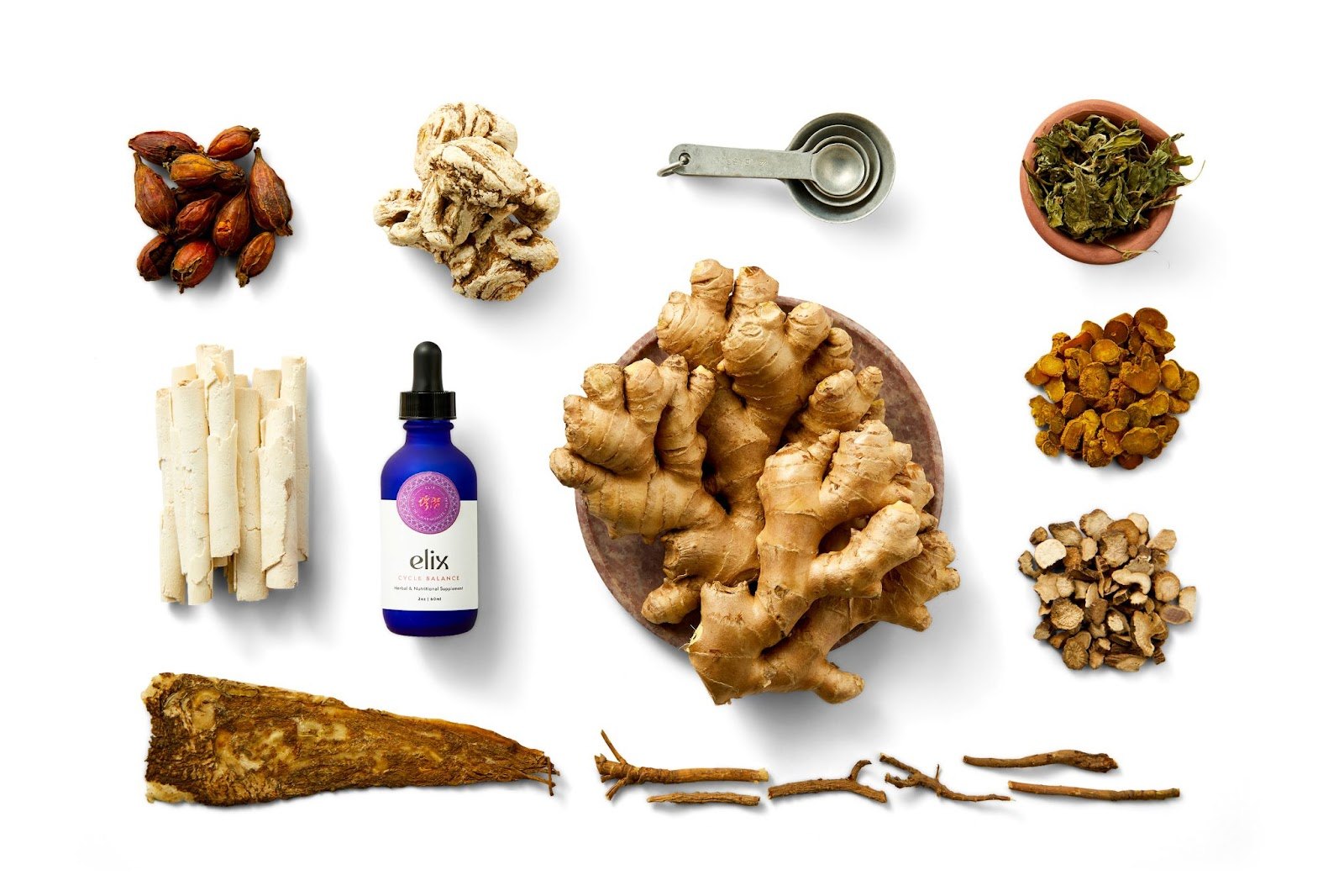 Cycle Balance bottle styled with raw herbal ingredients on white.