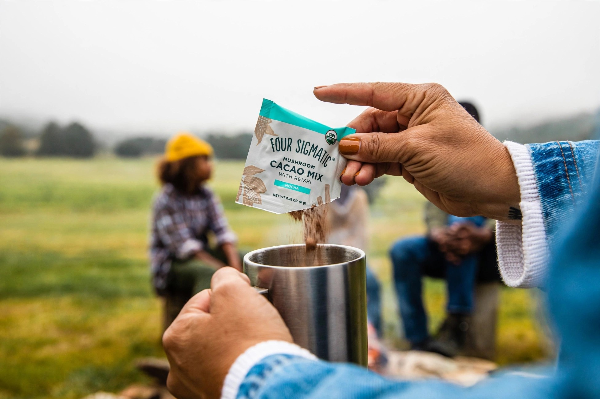 Outdoor preparation of Four Sigmatic cacao in a camping cup.