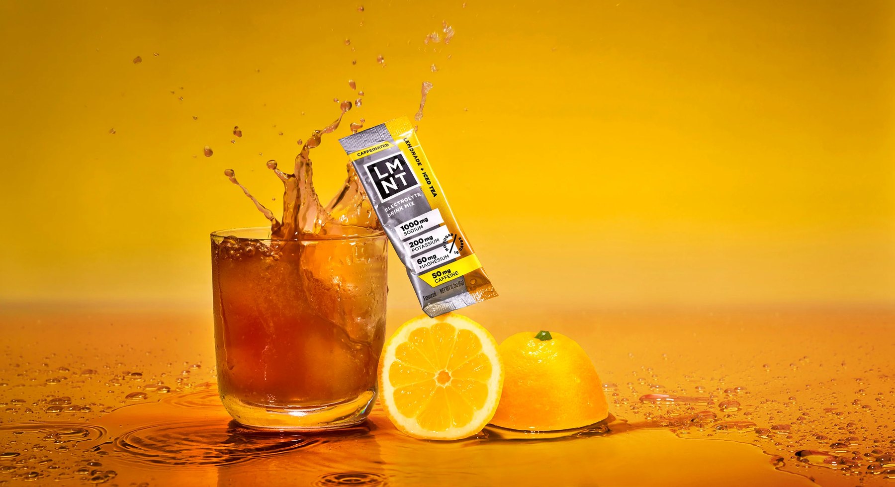 Lemon iced tea with LMNT electrolyte packet captured mid splash.