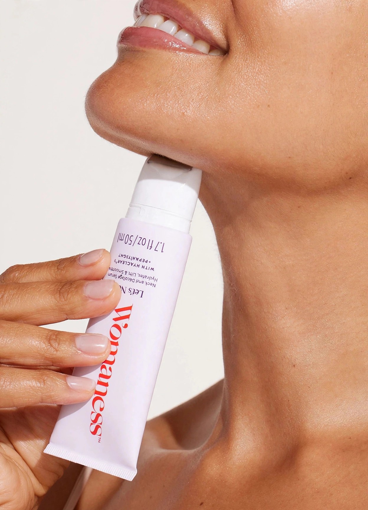 Close crop of Womaness neck serum in use.